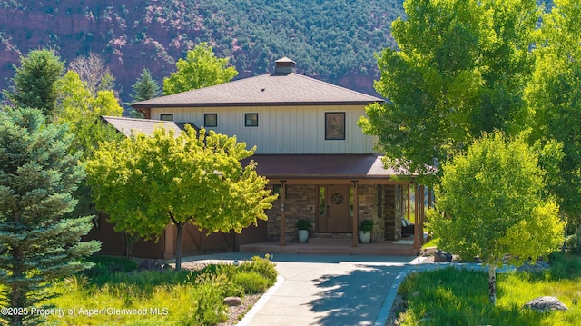 86 Sunrise Ct, Glenwood Springs, CO 81601 - view of front of property featuring covered porch, stone siding, a standing seam roof, a metal roof, and a view of trees