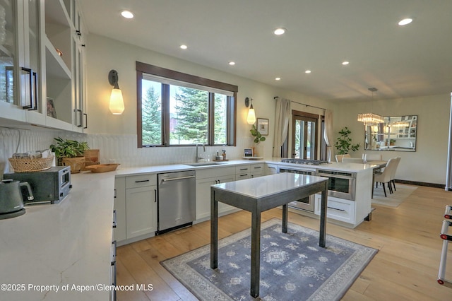 86 Sunrise Ct, Glenwood Springs, CO 81601 - kitchen featuring stainless steel appliances, a peninsula, a chandelier, tasteful backsplash, and recessed lighting
