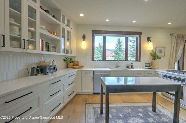 86 Sunrise Ct, Glenwood Springs, CO 81601 - kitchen with appliances with stainless steel finishes, decorative backsplash, white cabinetry, recessed lighting, and light wood-style flooring