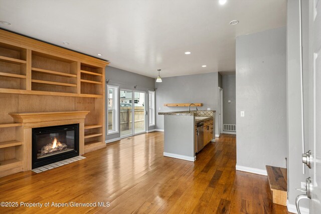 unfurnished living room featuring sink and dark hardwood / wood-style floors