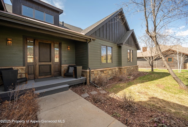 498 Red Cliff Cir, Glenwood Springs, CO 81601 - doorway to property with a porch, board and batten siding, stone siding, and a lawn