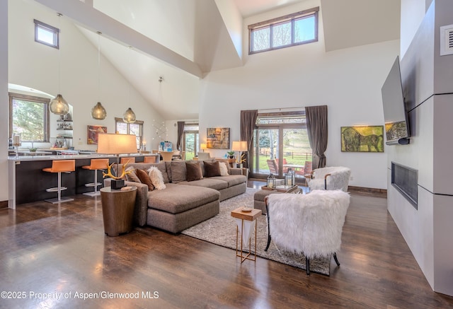 498 Red Cliff Cir, Glenwood Springs, CO 81601 - living area featuring a fireplace, a towering ceiling, baseboards, and dark wood finished floors
