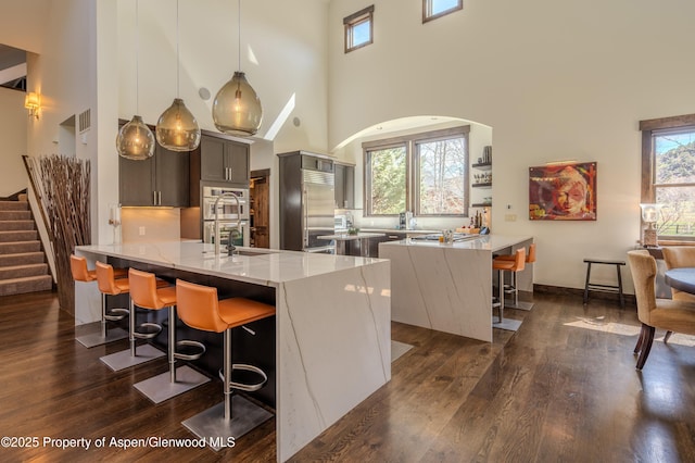 498 Red Cliff Cir, Glenwood Springs, CO 81601 - kitchen with a peninsula, dark wood-style floors, a breakfast bar, and appliances with stainless steel finishes