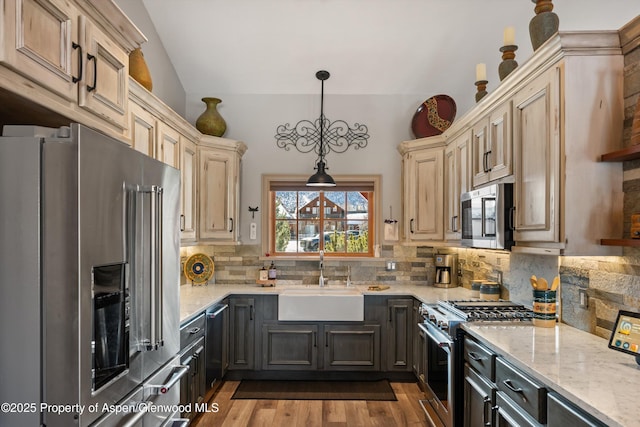 10 Laird Ln, Glenwood Springs, CO 81601 - kitchen with high end appliances, a sink, vaulted ceiling, decorative backsplash, and light stone counters