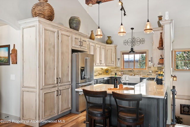 10 Laird Ln, Glenwood Springs, CO 81601 - kitchen with high end refrigerator, decorative backsplash, a kitchen bar, pendant lighting, and light wood finished floors