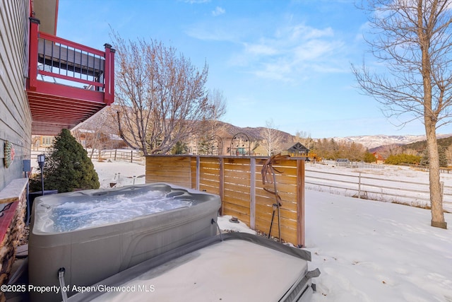 exterior space with a mountain view and a hot tub