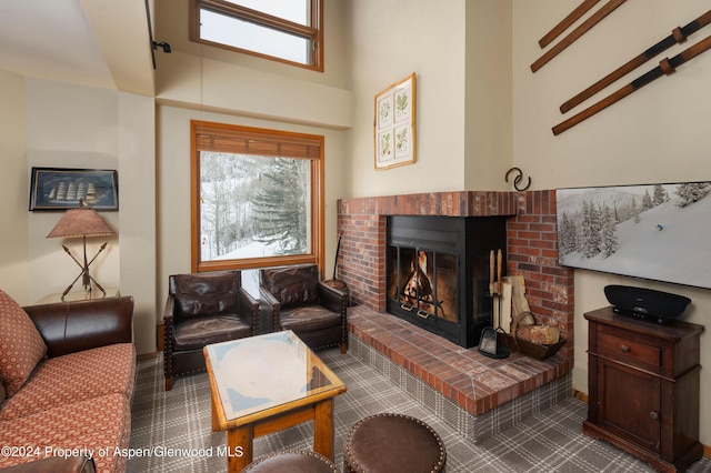 living room with a high ceiling and a brick fireplace