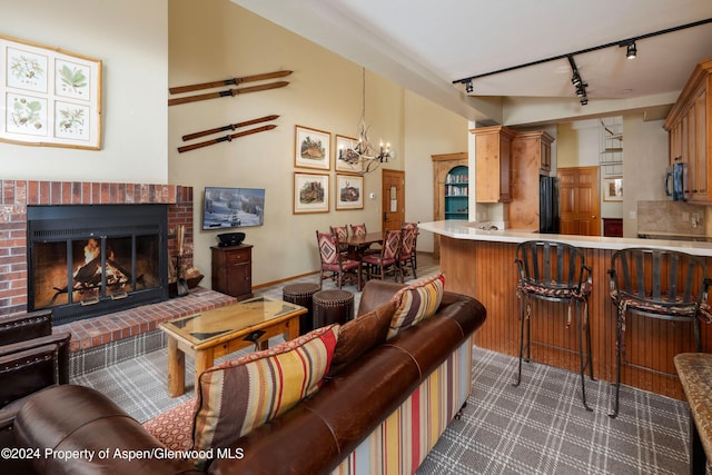 living room featuring a fireplace, rail lighting, and an inviting chandelier