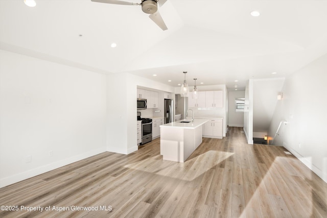 kitchen featuring sink, appliances with stainless steel finishes, an island with sink, pendant lighting, and white cabinets