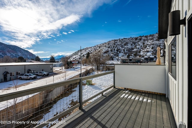 snow covered back of property with a mountain view