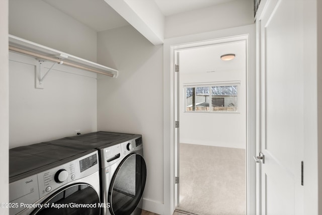 clothes washing area with washer and clothes dryer and carpet