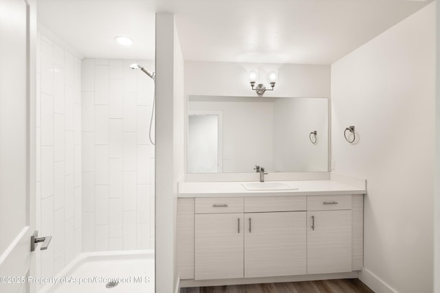 bathroom featuring walk in shower, vanity, and hardwood / wood-style flooring