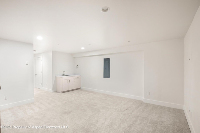 carpeted empty room with electric panel and sink