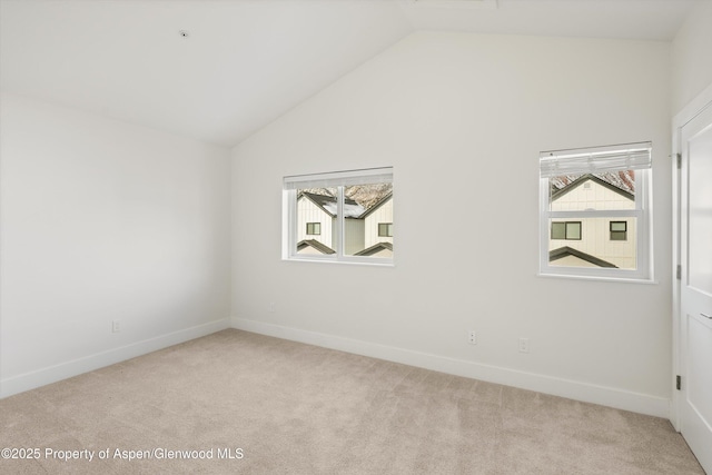 carpeted spare room with lofted ceiling and plenty of natural light