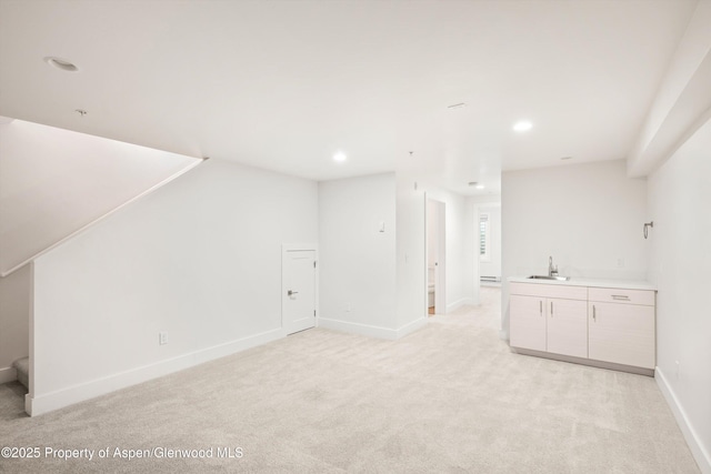 bonus room with a baseboard heating unit, light colored carpet, and wet bar