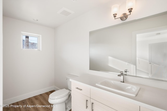 bathroom with hardwood / wood-style flooring, vanity, and toilet