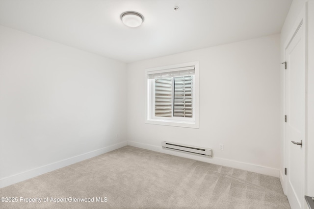 spare room featuring a baseboard radiator and light carpet