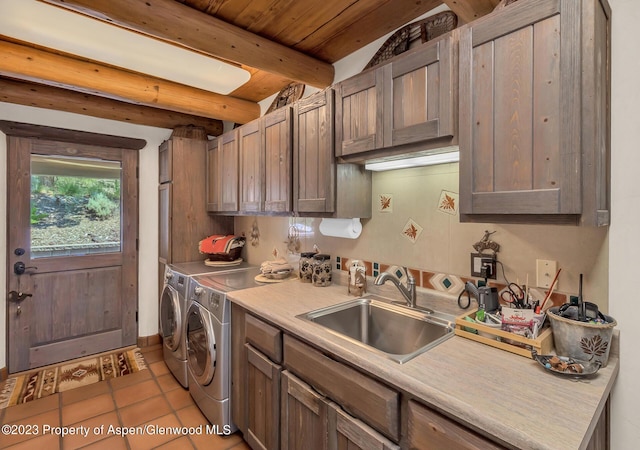 kitchen with sink, light tile patterned floors, separate washer and dryer, wooden ceiling, and beamed ceiling