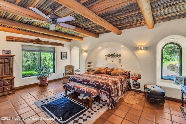 tiled bedroom with beamed ceiling, ceiling fan, and wood ceiling