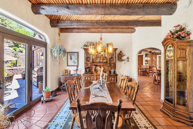 dining space featuring beam ceiling, a chandelier, tile patterned flooring, and wood ceiling