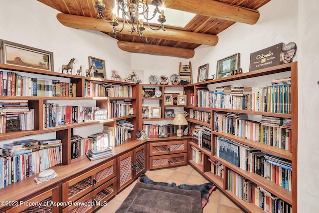 sitting room featuring beam ceiling, wooden ceiling, light tile patterned floors, and a chandelier