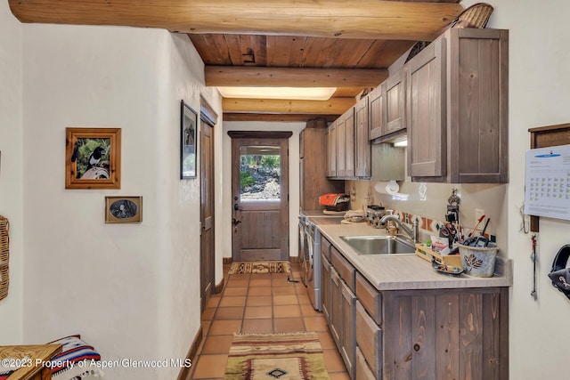 kitchen featuring beamed ceiling, wood ceiling, sink, and light tile patterned floors