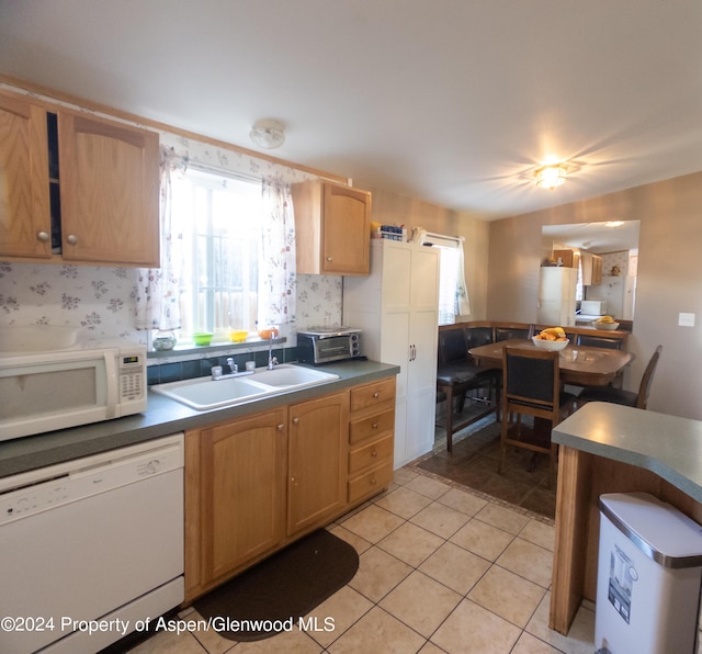 kitchen featuring white appliances, sink, and light tile patterned floors