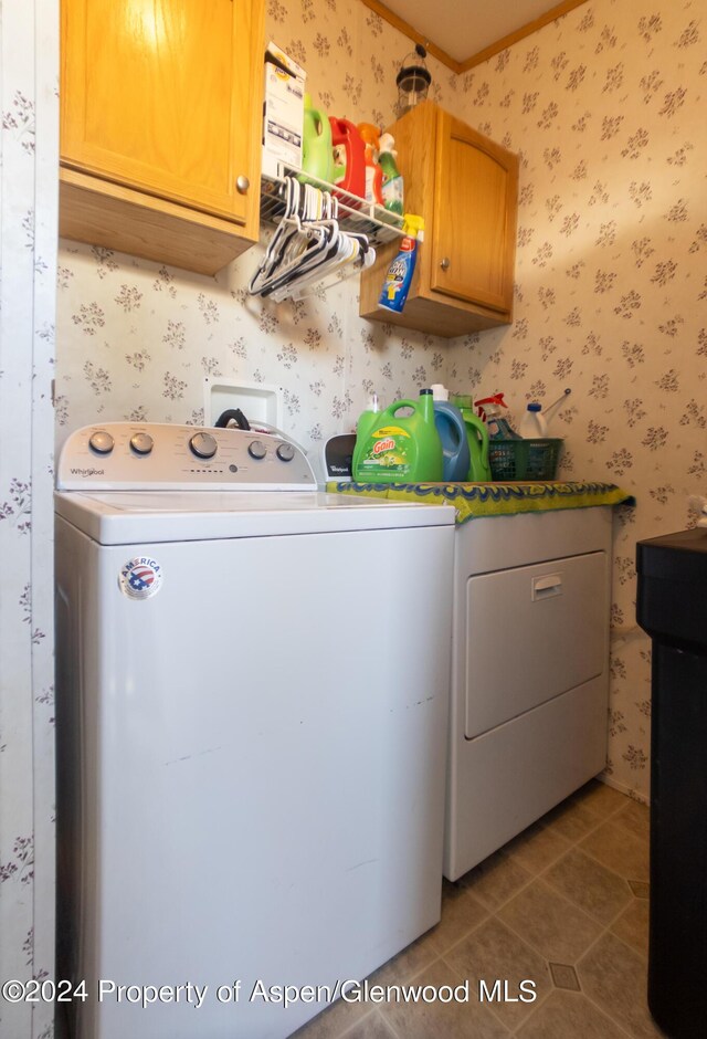 washroom featuring washing machine and clothes dryer, tile patterned floors, and cabinets