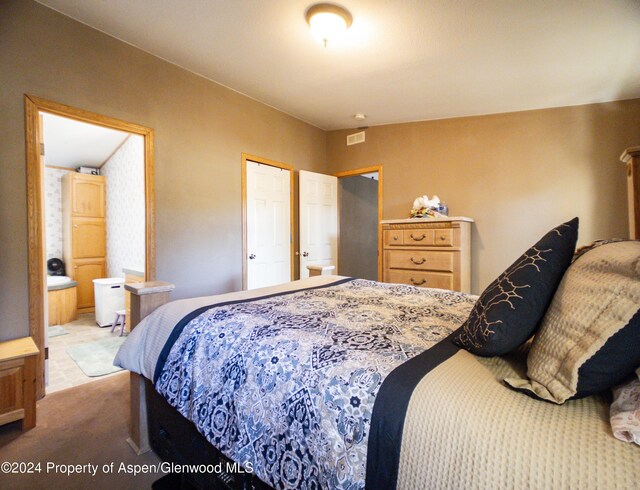 carpeted bedroom with ensuite bath