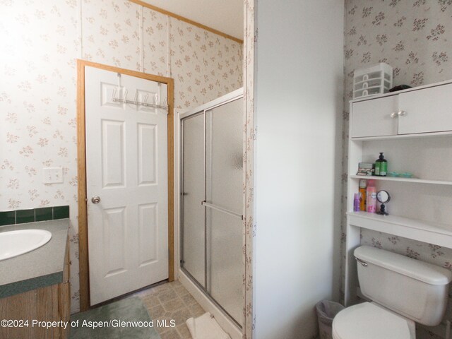 bathroom with vanity, toilet, and an enclosed shower