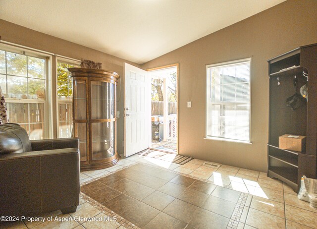 doorway featuring tile patterned floors and lofted ceiling