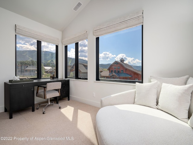 carpeted office featuring vaulted ceiling and a mountain view