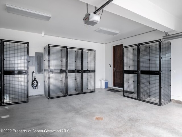 garage with electric panel and a garage door opener