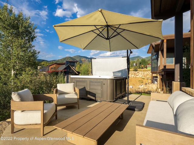 view of patio featuring an outdoor hangout area, a mountain view, and a hot tub