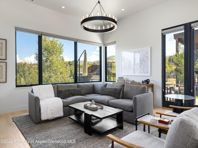 living room featuring an inviting chandelier, light hardwood / wood-style floors, and plenty of natural light