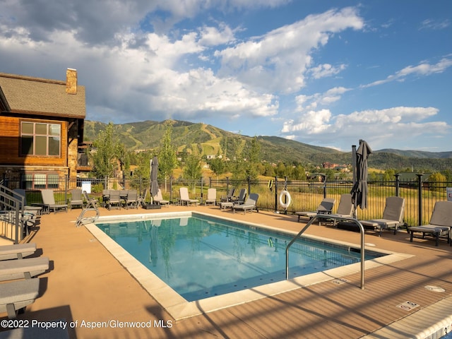 view of swimming pool featuring a patio area and a mountain view