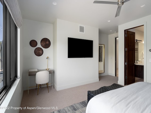 bedroom with ceiling fan, carpet flooring, and connected bathroom