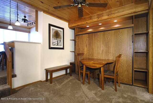 dining space featuring carpet flooring, ceiling fan, and wood ceiling