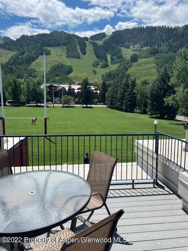 wooden terrace featuring a lawn and a mountain view