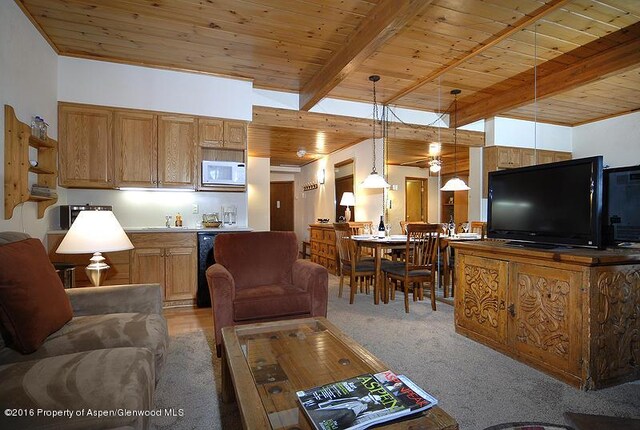 living room featuring beamed ceiling, wooden ceiling, and light carpet