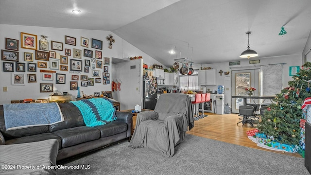 living room with hardwood / wood-style flooring, lofted ceiling, and sink