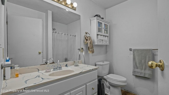 bathroom featuring a shower with shower curtain, vanity, and toilet