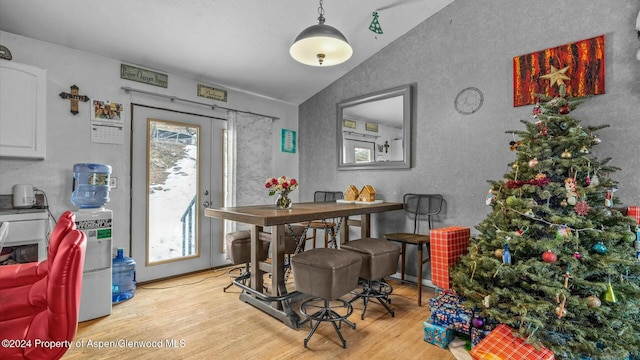 dining area with light hardwood / wood-style floors and vaulted ceiling