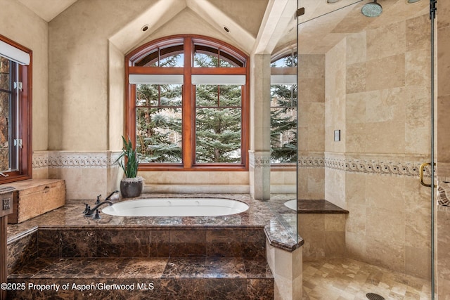 bathroom featuring a wealth of natural light, a stall shower, lofted ceiling, and a bath