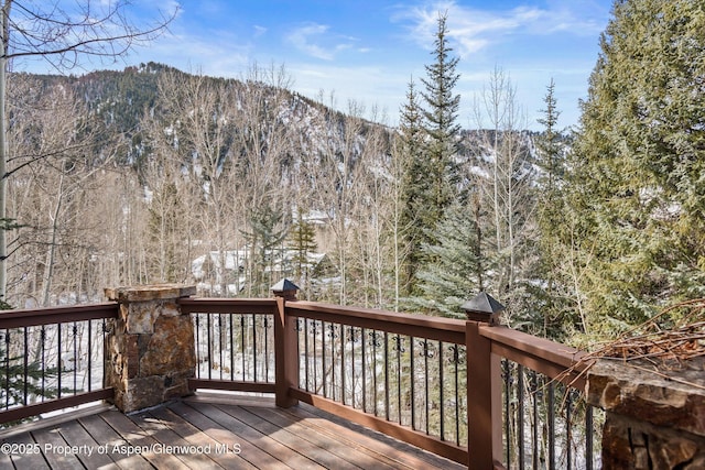 deck with a forest view and a mountain view