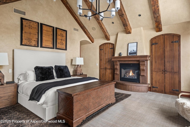 carpeted bedroom with high vaulted ceiling, beamed ceiling, visible vents, and an inviting chandelier