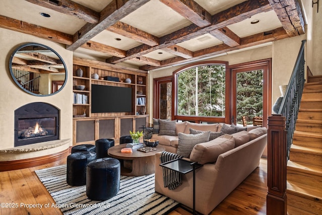 living room with a glass covered fireplace, beam ceiling, coffered ceiling, and hardwood / wood-style floors