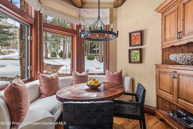 dining space featuring a high ceiling, breakfast area, hardwood / wood-style flooring, and an inviting chandelier