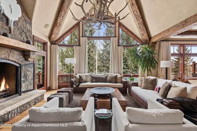 interior space featuring high vaulted ceiling, a stone fireplace, and beam ceiling