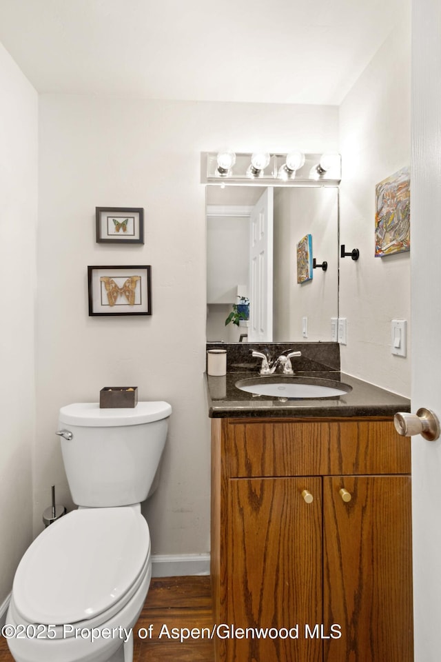 bathroom featuring hardwood / wood-style flooring, vanity, and toilet